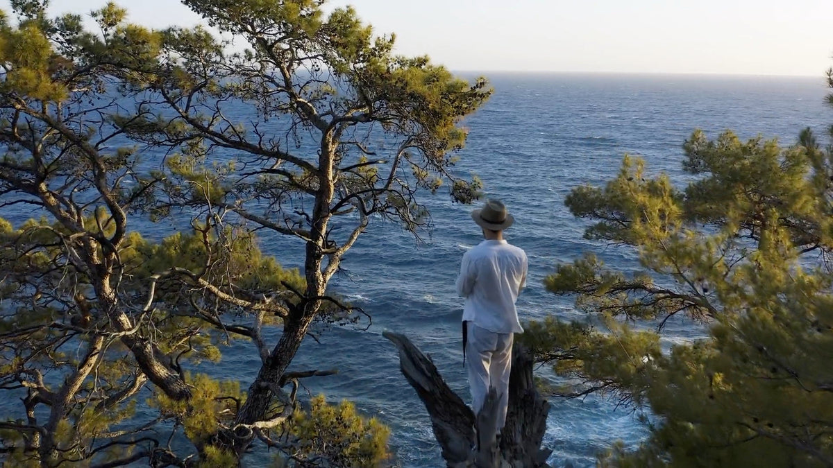 A man overlooking the Mediterranean Sea between pine trees